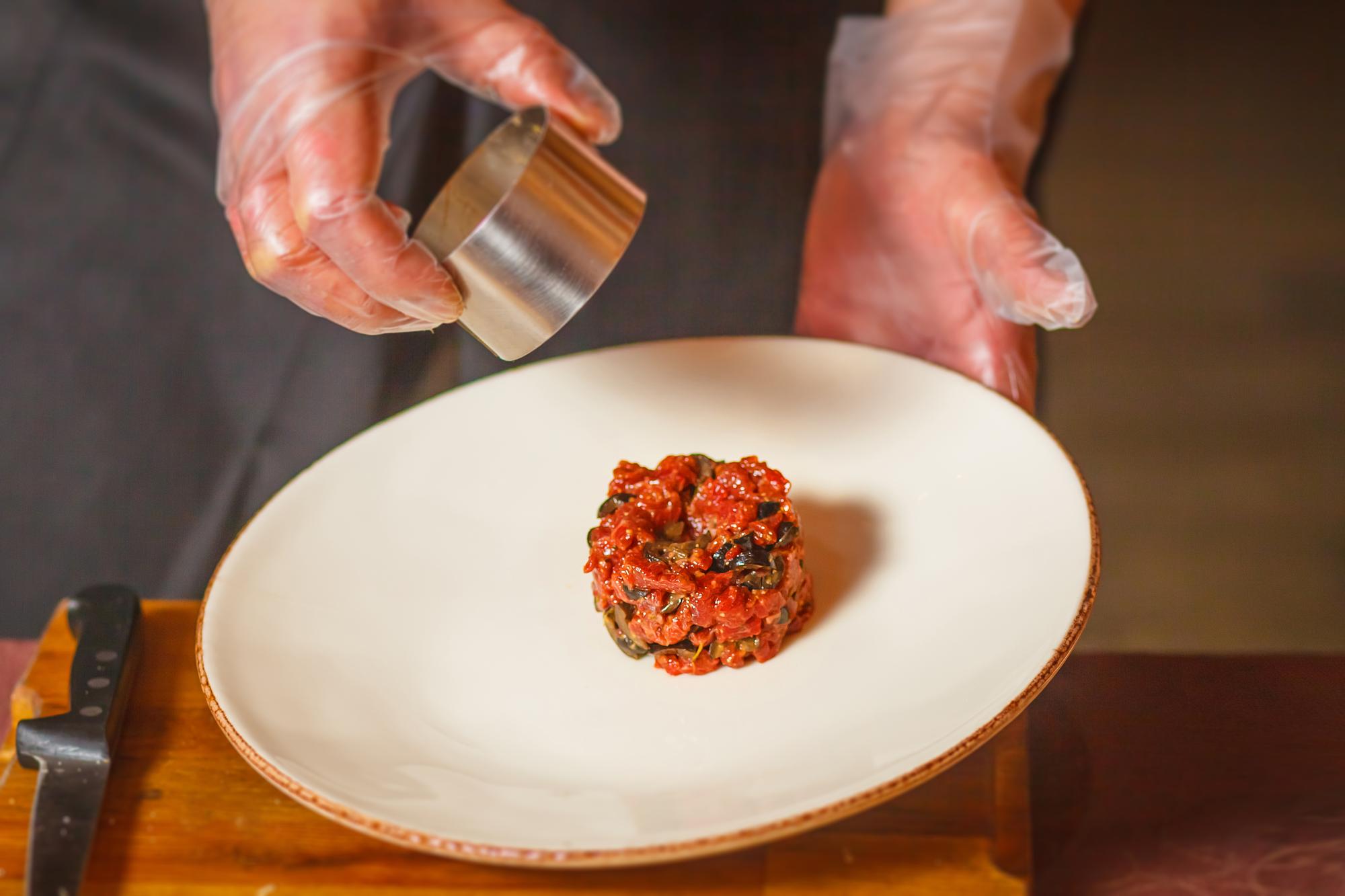 Artisan chef hands seasoning a plated dish