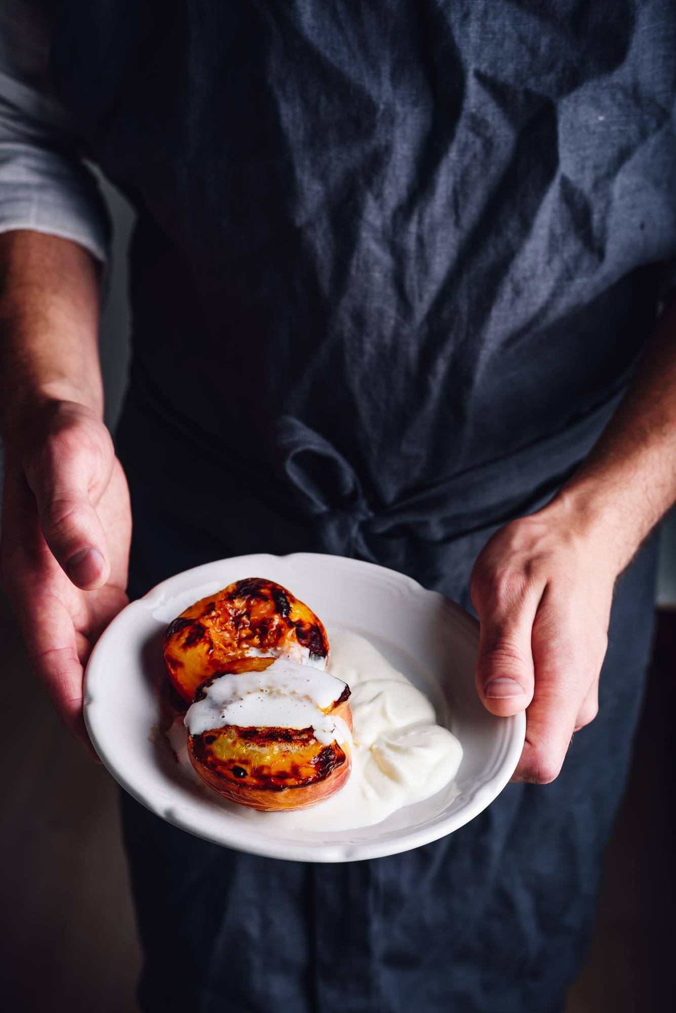 Chef demonstrating plated dish in luxury kitchen